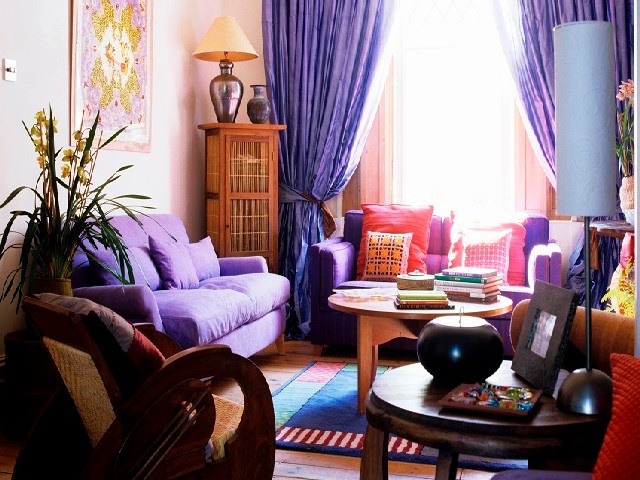A Living Room With Upholstered Furniture And Purple Curtains At The Window